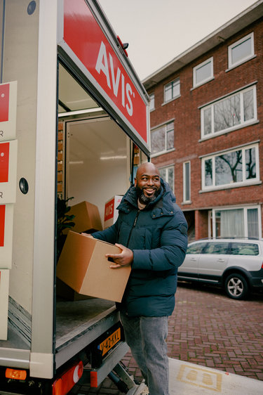 Man lifts box from Avis moving van