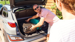 Man zet koffers in de kofferbak voor zomervakantie trip