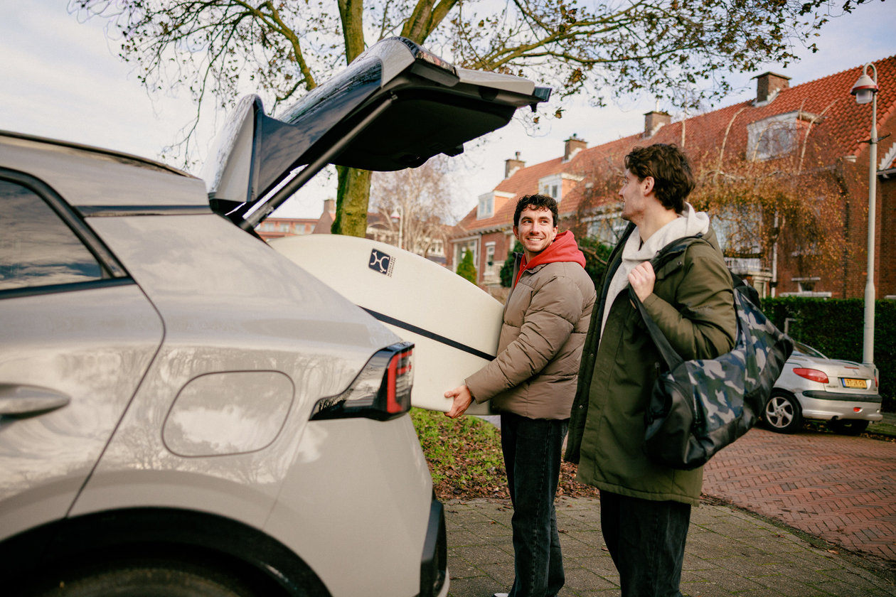 Twee mannen pakken surfspullen in de auto