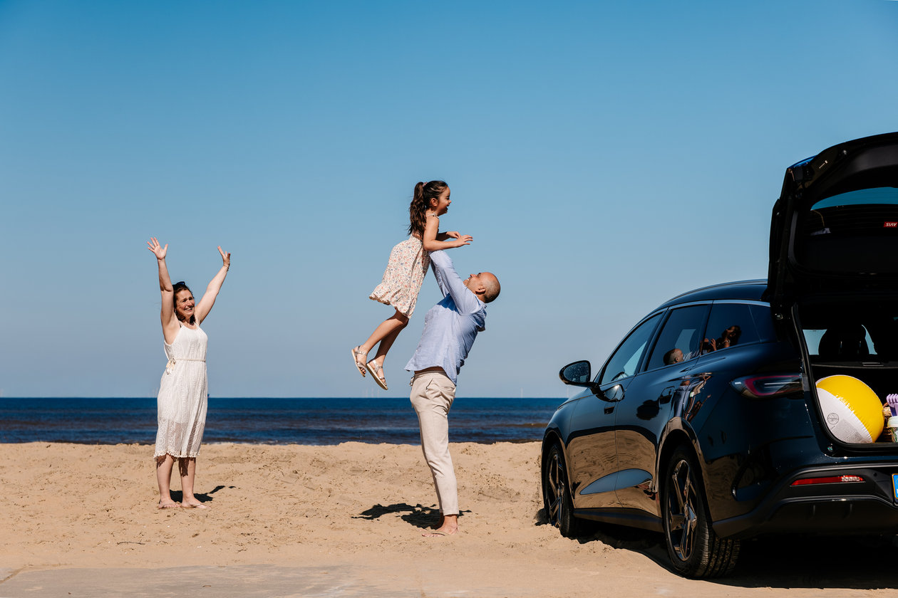 Family with the car on the beach