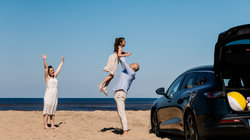 Gezin met de auto op het strand