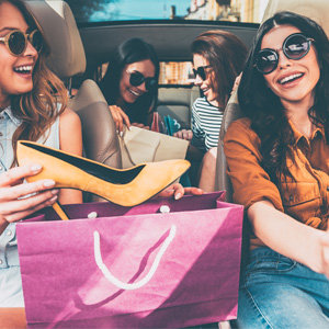 4 vriendinnen zitten in de auto na het shoppen