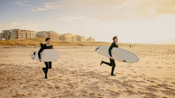 Surfers rennen op het strand