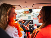 Vriendinnen in auto met koningsdag outfit