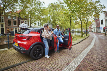 Jongvolwassenen stappen de auto uit in Utrecht