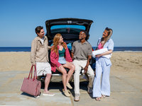 Vrienden in de auto op het strand