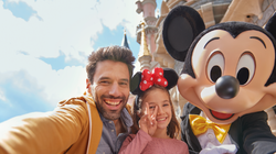 Vader en dochter maakt selfie met Mickey Mouse in Disneyland