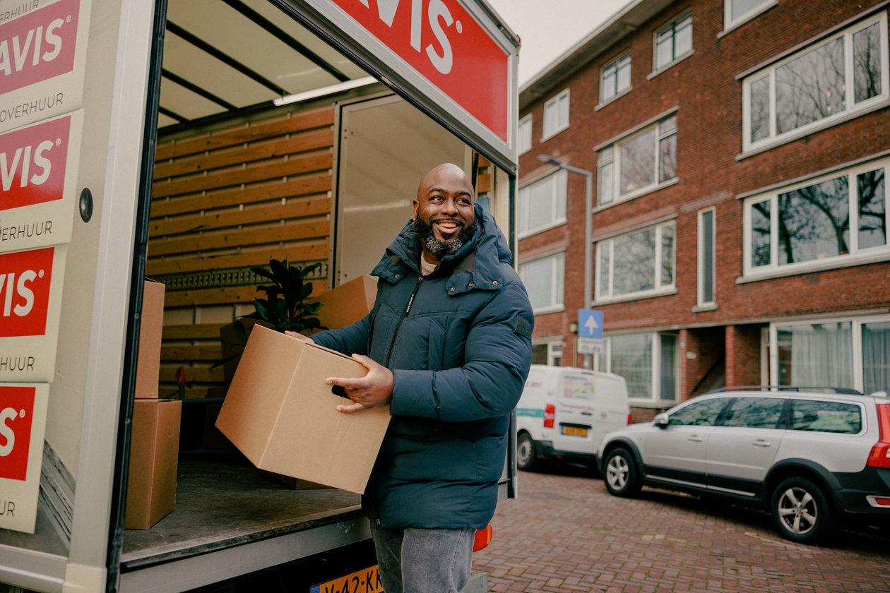 Man lifts box from Avis moving van