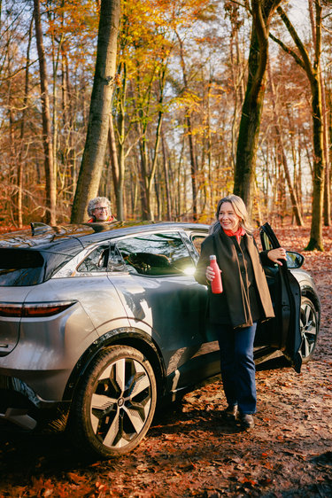 Senior couple stepping out of their car in the forest