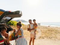 Familie op het strand met de auto