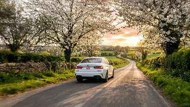 Avis auto rijd op een landweg in de lente