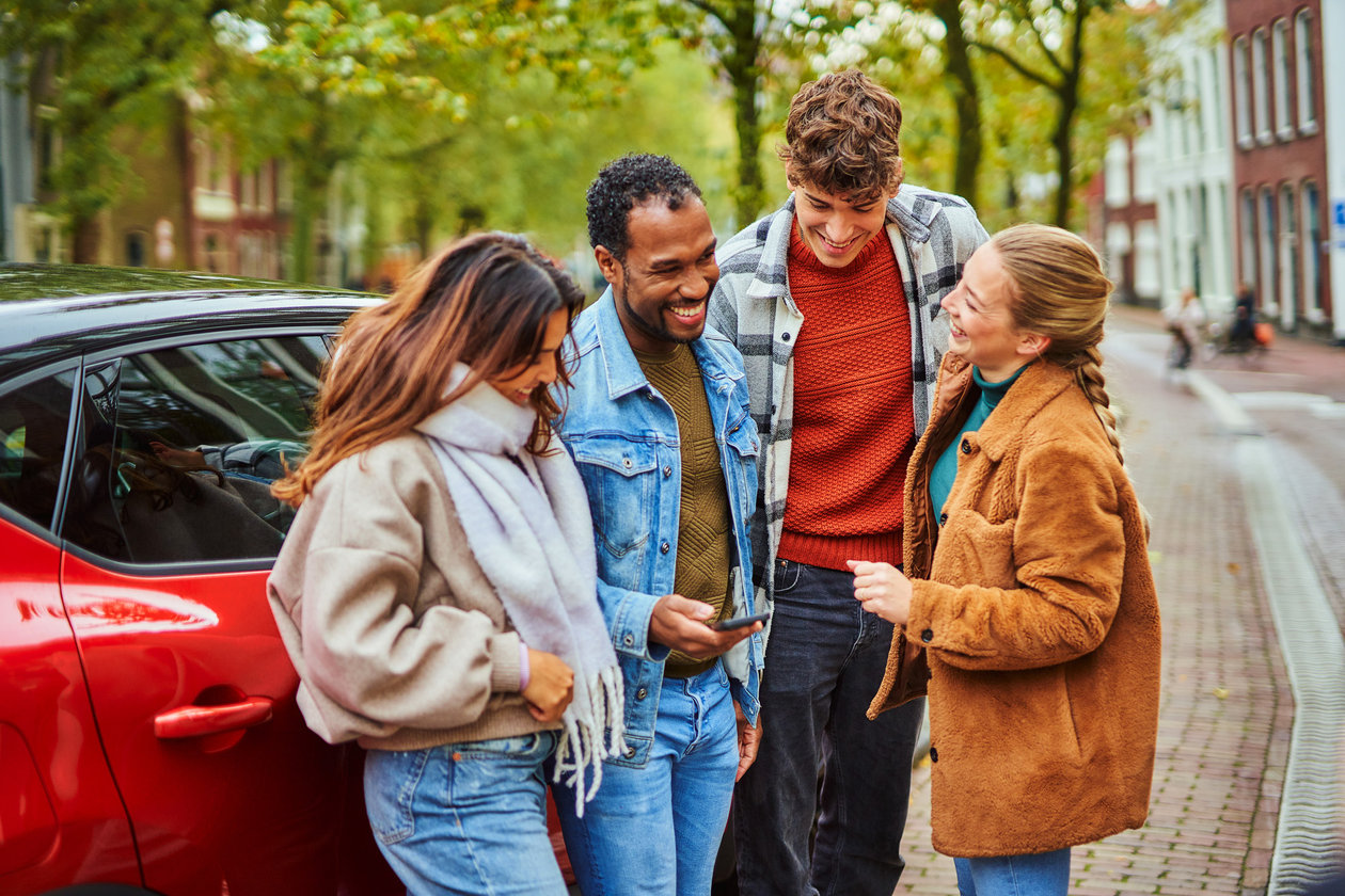 Vier jongeren hangend bij de auto