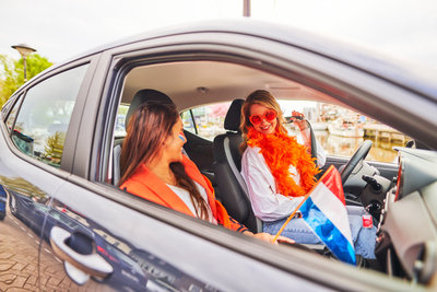 Vriendinnen in auto naar koningsdag